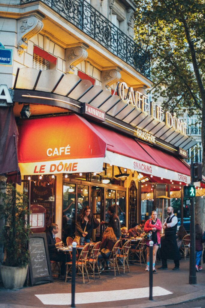 pexels-photo-1850620-1850620 Bustling Parisian café with people dining outdoors, vivid and inviting atmosphere.