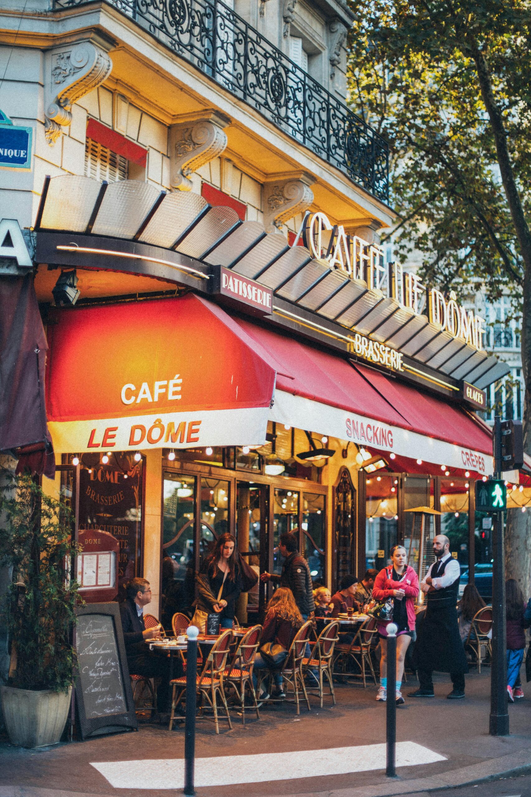 Bustling Parisian café with people dining outdoors, vivid and inviting atmosphere.
